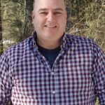 An image of Jon Corbett standing in the woods.