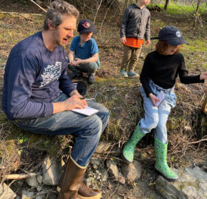 Learners taking notes and observations by the riverside.