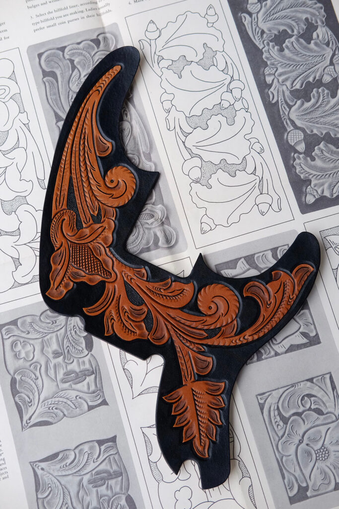 Black and tan pick guard with floral designs.