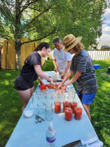 Three people canning and preserving fish.