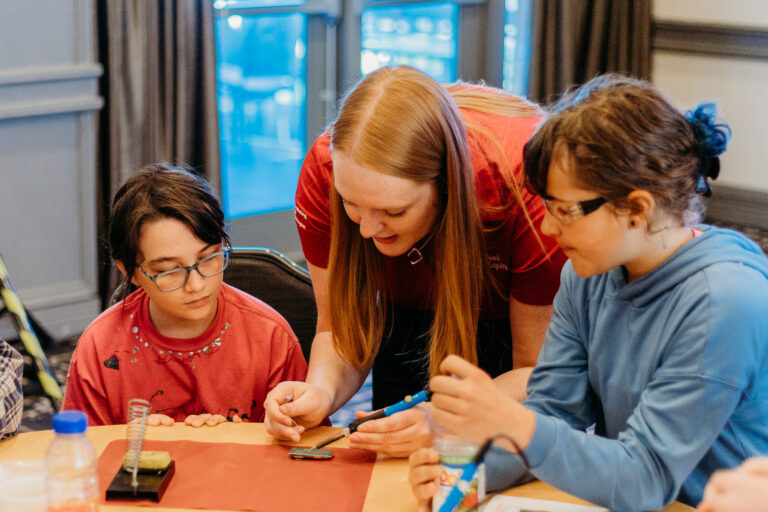 A Makers Making Change team member demonstrates how to solder at a build event (Courtesy of Makers Making Change)
