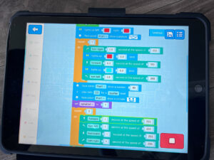 A tablet screen with code instructions from MIT app Scratch